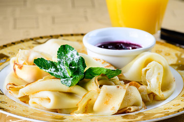 Sweet delicious pancake blini with jam and mint at the table. New restaurant menu for the holiday...