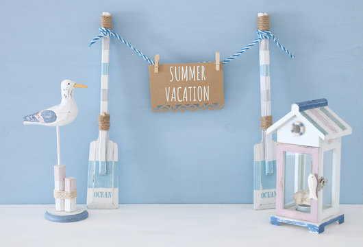 nautical concept with hanging note on a string next to beach house and seagull over blue background.