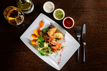 Delicious prepared shrimp with tomatoes, sauce and basil leaves at a restaurant. Top view, flat lay
