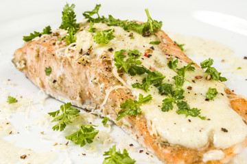Fried Salmon with cheese sauce, parsley and pepper.