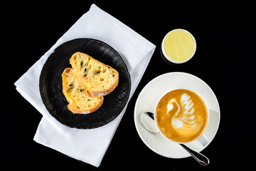 Fresh warm cup of cappuccino latte and fresh bread at a cafe. Top view, flat lay