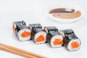 Fresh delicious Japanese sushi with salmon on light background