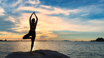 Meditation yoga lifestyle woman silhouette on the Sea sunset, relax vital. Healthy Concept