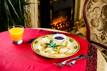 Sweet delicious pancake blini with jam and mint at the table. New restaurant menu for the holiday...