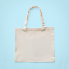 Tote bag mock up canvas white cotton fabric cloth for eco shoulder shopping sack mockup blank template isolated on pastel blue background (clipping path)