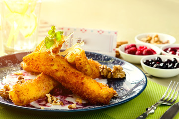 Sweet delicious pancake blinis with crispy crust with jam and walnut with copyspace in the plate in rays of the sun. New restaurant menu for the holiday Maslenitsa