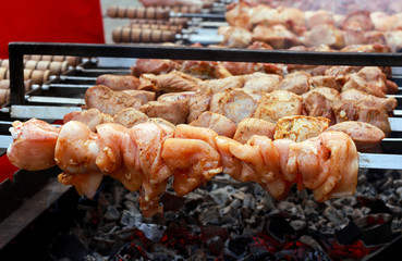 Chicken pieces on sticks grilling