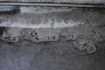 The texture of concrete, with cavities from under the air bubbles