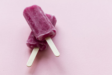 Raspberry flavour summertime ice lollies on a pink background