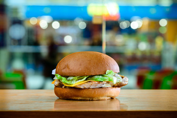Delicious fast food Burger served with fish, cheese and salad in the cafe on light background
