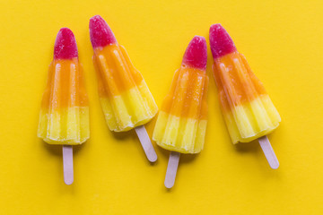 Rocket shaped summer ice lolly on a bright yellow background