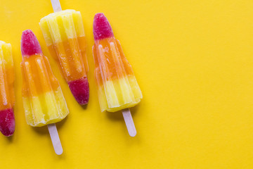 Rocket shaped summer ice lolly on a bright yellow background