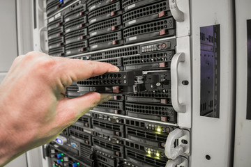 Replacing the hard drive is in the storage servers. Technical support of Internet equipment. The engineer repairs the computer server. Selective focus