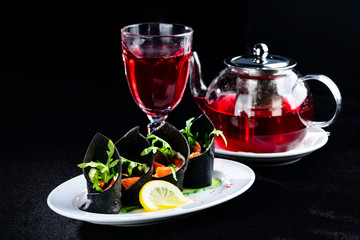 Russin cuisine in modern form. Homemade black pancakes (blini) with cuttlefish ink served with salmon and tomatoes and warm red tea