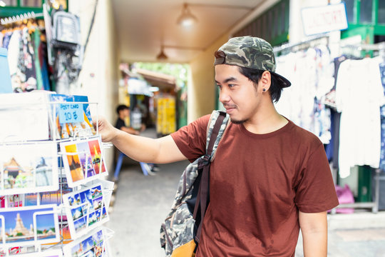 Japanese tourist enjoying sightseeing exploring city and buy postcards at Tha Pae Walking Street, Chiang mai Province, Thailand