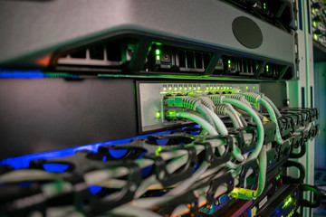 Servers and switches are located in the server room of the data center. Connecting the Internet wires with computer equipment. Cabling in the server cabinet.
