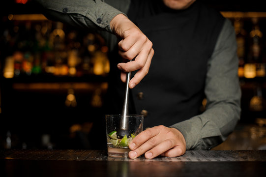Barman mixing a cane sugar with lime