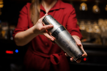 Fototapeta premium Female bartender making cocktail at the steel bar counter