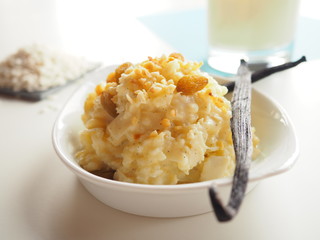 Creamy vanilla rice pudding with rice and milk on white and blue background