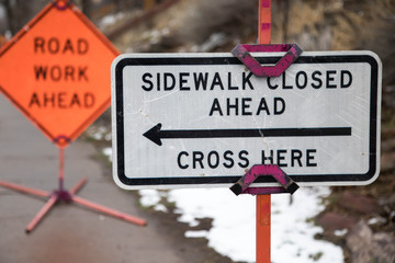 Focus on a Sidewalk Closed Ahead Cross Here sign