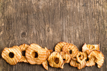 Obraz na płótnie Canvas Healthy snack. Tasty dried apple rings chips on wooden background with copyspace for text. Top view, flat lay