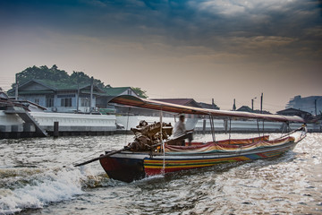 typical boat of the place navigating the chao phraya river in the city of bangkok thailand