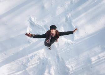 Snow angel concept. Angel wings on the snow. The girl spreading her arms.