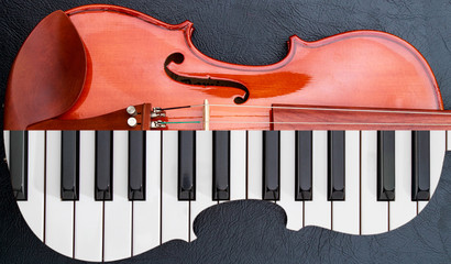 piano keys in to the violin on the black leather table, half keyboard like violin shape