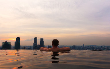 Man In Infinity Pool at Marina Skypark Bay in Singapore Skyline