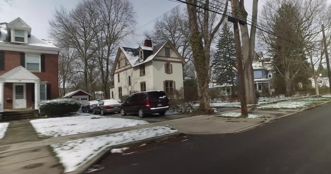 A driver's side perspective on the streets of an upscale residential neighborhood on a late winter day. Pittsburgh suburbs.  	