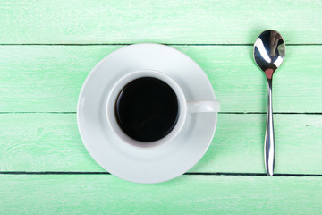 Cup of coffee, spoon on a wooden background. Top view