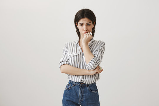 Frustrated And Worried Woman Got Into Huge Trouble. Anxious Upset Attractive Girl In Casual Blouse Holding Fist Over Mouth And Frowning, Being Nervous While Waiting Results Of Pregnancy Test