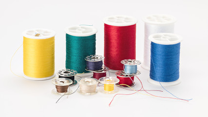 Sewing thread of different colors on a white background