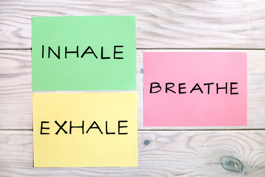 Words inhale,exhale and breath on wooden table.
