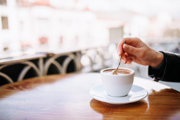 Taking a break. Drinking a cup of coffee on the balcony. Close-up.