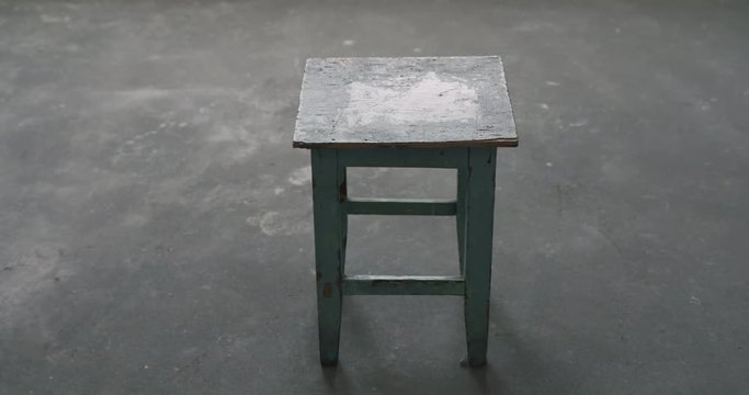 Slow motion handheld shot of old stool in empty room during renovation
