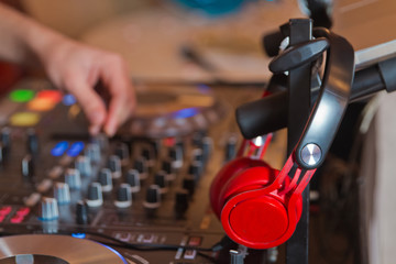 Dj mixer with headphones at nightclub . Dj mixes the track in the nightclub at party . DJ. sound equipment . Controller, headphone, DJ, equipment