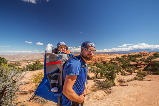 A family with baby son visits Arches National Park in Utah, USA