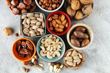 mixed nuts on grey background. Healthy food and snack. Walnut, pecan, almonds, hazelnuts and...