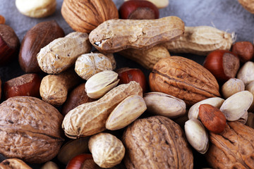 mixed nuts on grey background. Healthy food and snack. Walnut, pecan, almonds, hazelnuts and cashews.