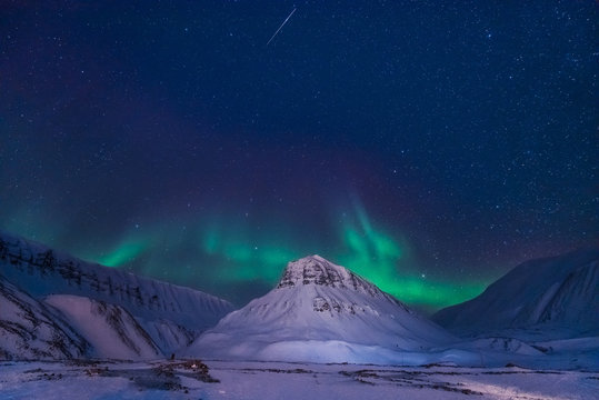 The polar arctic Northern lights aurora borealis sky star in Norway Svalbard in Longyearbyen city man mountains