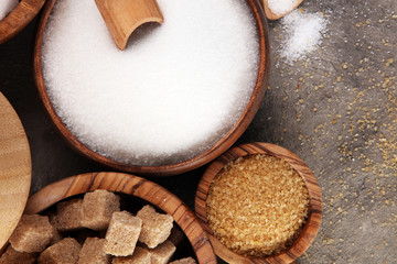 Various types of sugar, brown sugar and white on table