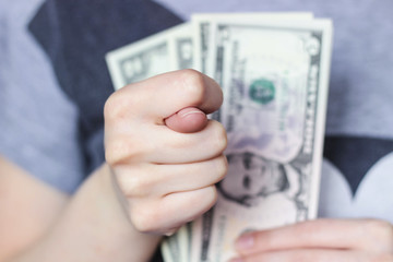 Fig gesture with a right hand close-up on the background of money