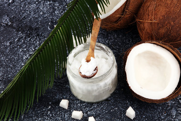 coconut oil and fresh coconuts on grey background.