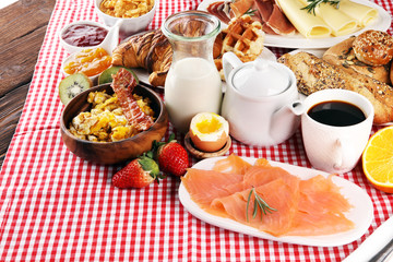 breakfast on table with waffles, croissants, coffe and juice