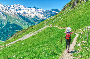 Fototapeta na wymiar Swiss Alps. A man in a white hat, a traveler in a mountain alpine country walk along the path. Landscape of the Swiss Alps, Engelberg Resort