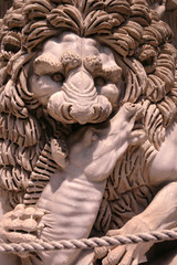 Sculpture of a medieval lion head of stone who keeps prey in his paws Italy 