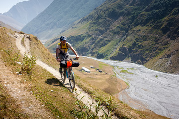 Mountain biker is travelling in the highlands of Tusheti region, Georgia