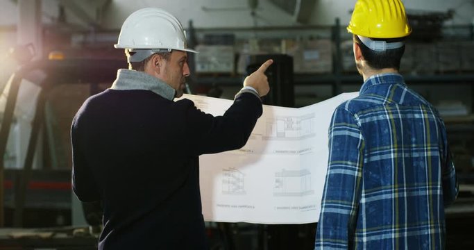 on a construction site, two workers or engineers or architects control the design and construction of the building with high energy savings. Concept: construction, worker, engineering, design.