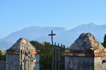 Open church gate with a cross and a landscape behind it